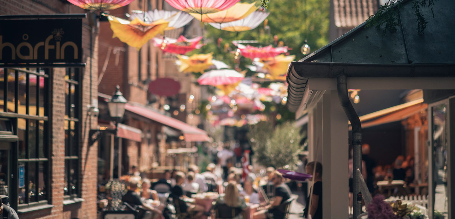 Passage med paraplyer og caféliv