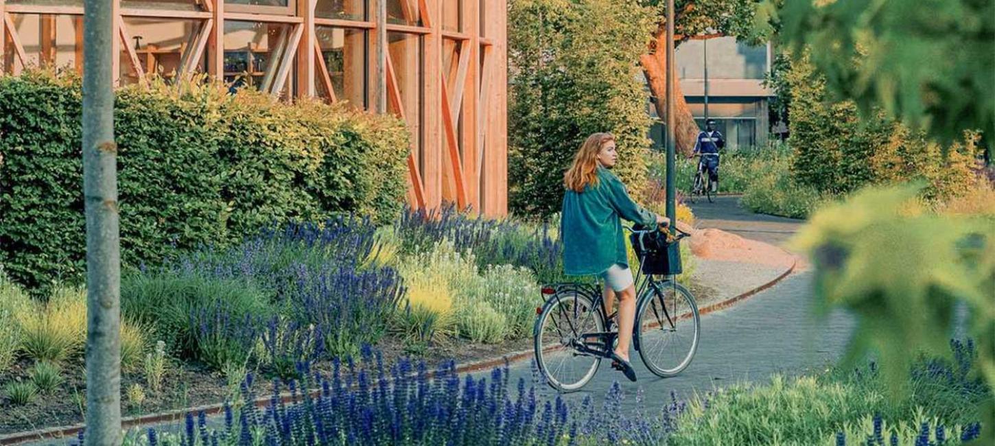 Pige på cykel ved hca hus