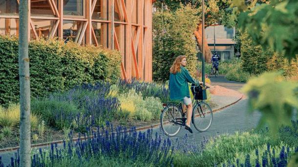 Pige på cykel ved hca hus