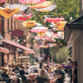 Passage med paraplyer og caféliv