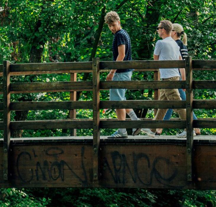 Fodgængere på bro med grafitti