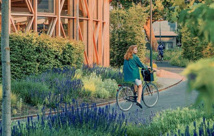 Pige på cykel ved hca hus